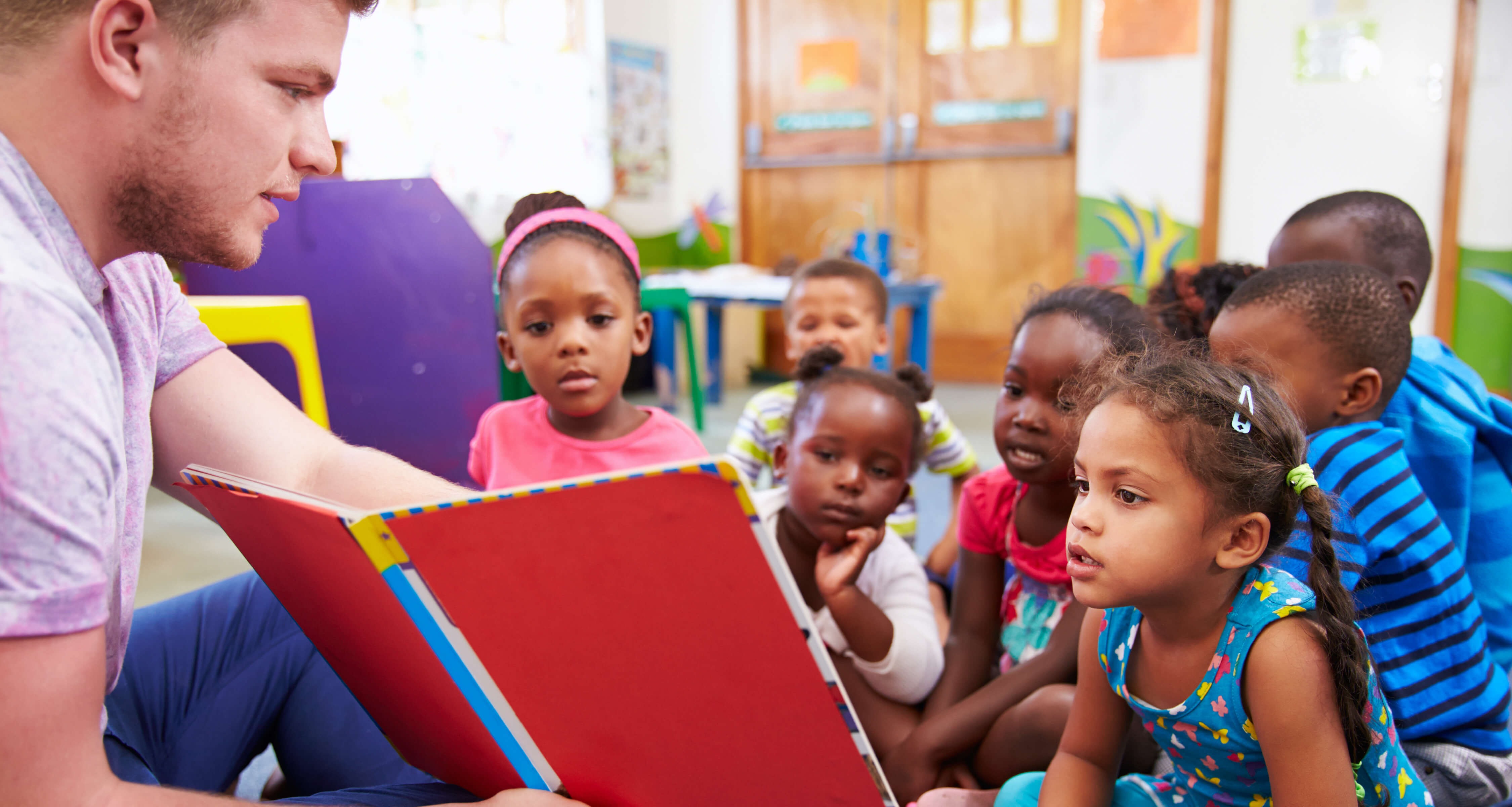 teacher reading to kids on floor-1