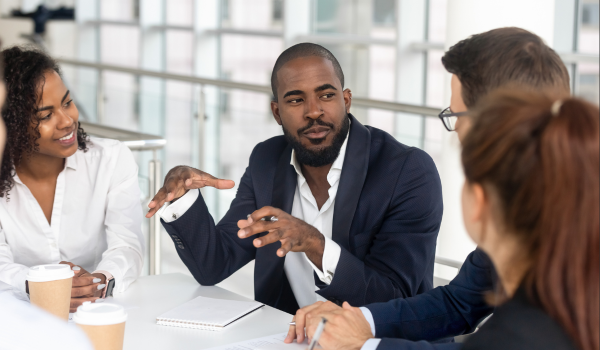 Man sits at a table with other professionals.