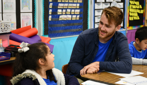 Excited program teacher helping student with technology