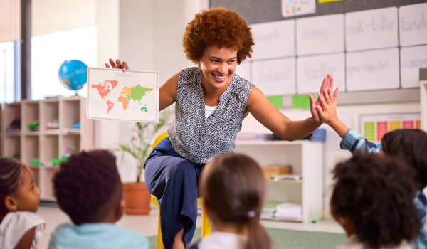 Group of kids sits with a teacher during a summer youth program.