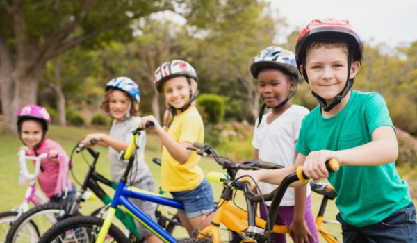 A group of young children stand with their bikes during a parks and rec program. 