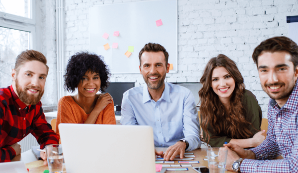 A group of young educators sit around a table for a professional development session.
