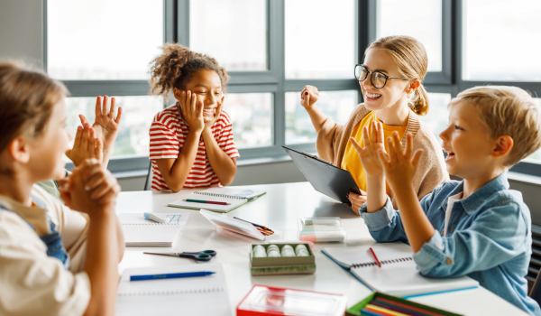 A afterschool teacher sits with a group of students.