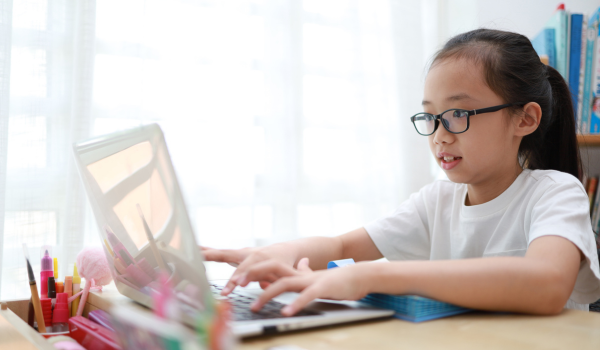 Focused little girl working on a computer at an after school program.