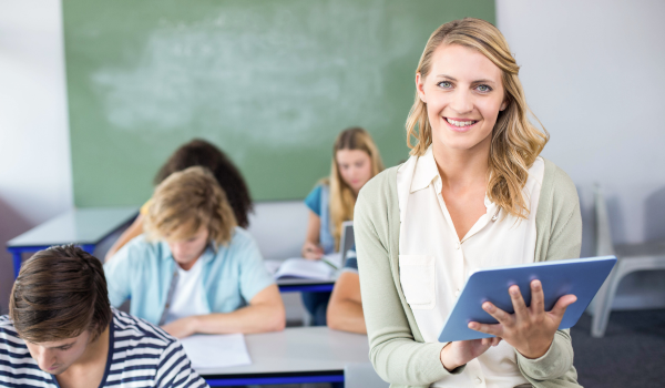 Afterschool teacher sits in a classroom among students. 