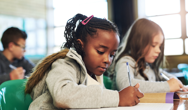 Two young girls complete an activity during an afterschool youth program.