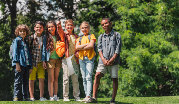 A group of young campers stands on a hill during a summer camp.